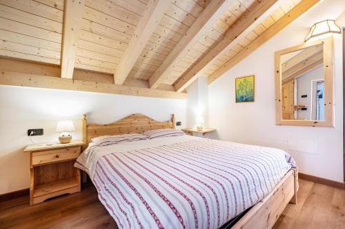 a bedroom with a bed and a wooden ceiling at Agriturismo Malga Riondera in Ala