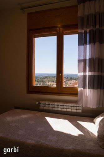 a bedroom with a window with a view of the countryside at Casa Garí in Horta de San Joan