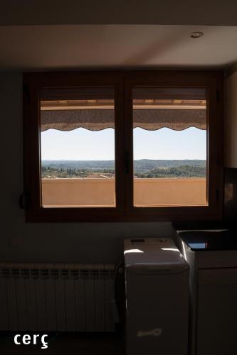 two windows in a kitchen with a view of a field at Casa Garí in Horta de San Joan