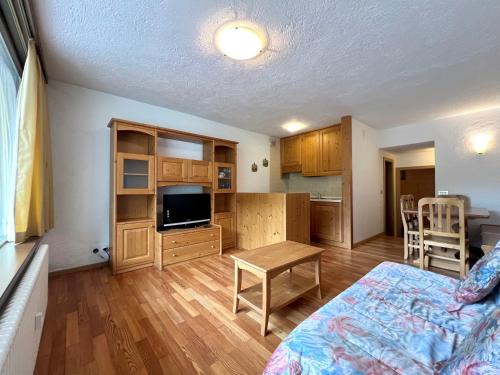 une chambre avec un lit et une cuisine avec une table dans l'établissement Bilocale Slalom, à Madonna di Campiglio