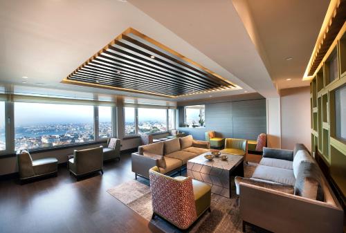 a living room with couches and a view of a city at The Marmara Taksim in Istanbul