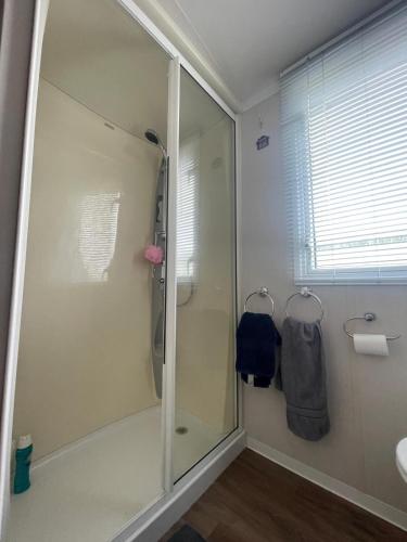 a bathroom with a shower with a glass door at Lake District Stunning Lodge in Plumbland