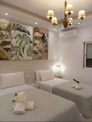 a bedroom with two beds and a painting on the wall at Warm Harbor in Santa Coloma de Gramanet