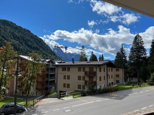un immeuble d'appartements avec une grue dans les montagnes dans l'établissement Bilocale Slalom, à Madonna di Campiglio