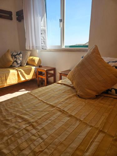 a bedroom with two beds and a large window at Zabava Odivelas in Odivelas