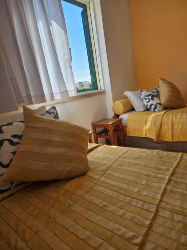 a hotel room with two beds and a window at Zabava Odivelas in Odivelas