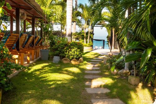 a pathway with chairs and the ocean in the background at Casa Verano Beach Hotel - Adults Only in Santa Marta
