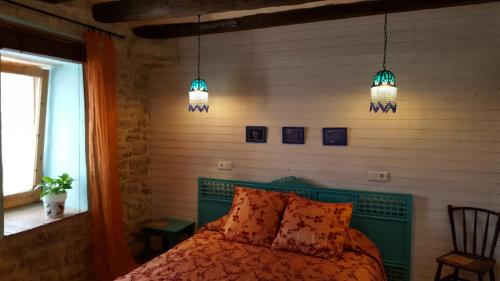 a bedroom with a green bed with two lights at Les Cavallerisses in Guialmons