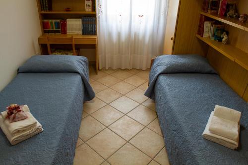 a bedroom with two beds and a book shelf at Apartments Delise in Scardovari