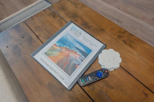 a book sitting on a table next to a remote control at #StayInMyDistrict Bluebird Cottage Coos Bay in Coos Bay