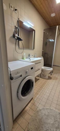 a bathroom with a washing machine and a sink at Terrace Apartments at Kirkkokatu in Savonlinna