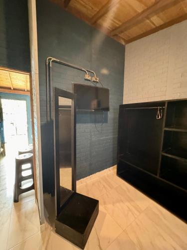 a shower in a room with a black wall at POSADA MISS ANIBEL in San Andrés