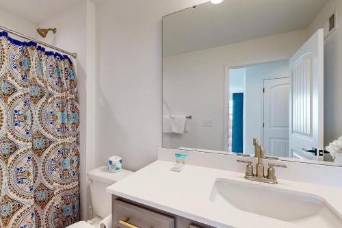 a bathroom with a sink and a toilet and a mirror at Marlin Chase in Ocean View