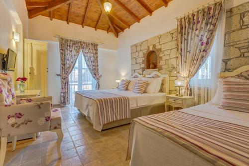 a bedroom with two beds and a stone wall at AlaNarin Konak in Alaçatı
