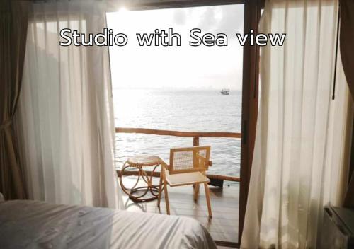 a bedroom with a balcony with a view of the ocean at De' Ocean land เดอโอเชี่ยนแลนด์ เกาะล้าน in Ko Larn