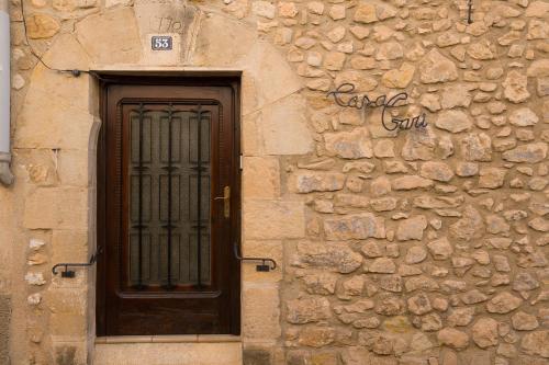 a stone building with a wooden door and a window at Casa Garí in Horta de San Joan