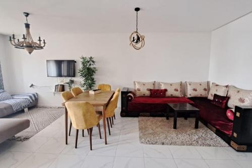 a living room with a couch and a table at Appart familial près de la plage Val d'or in El Harhoura