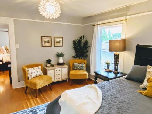 a bedroom with a bed and two chairs and a window at Historical Entertainer 3 Bedroom Townhouse AC PNW in Albany