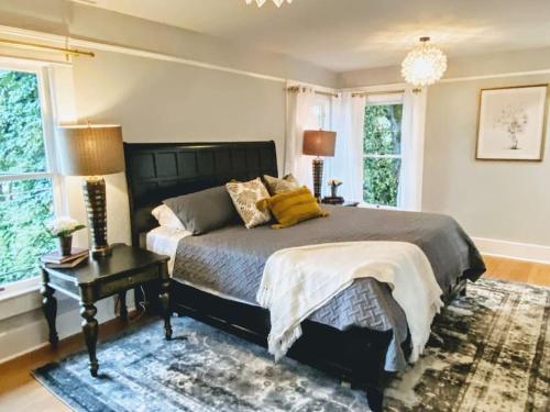 a bedroom with a bed and a table and windows at Historical Entertainer 3 Bedroom Townhouse AC PNW in Albany