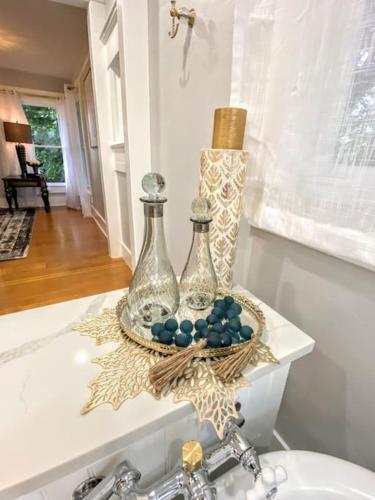 two glass bottles sitting on top of a bathroom sink at Historical Entertainer 3 Bedroom Townhouse AC PNW in Albany