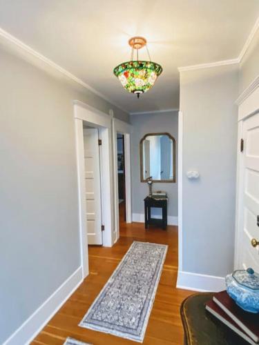 a living room with a chandelier and a wooden floor at Historical Entertainer 3 Bedroom Townhouse AC PNW in Albany