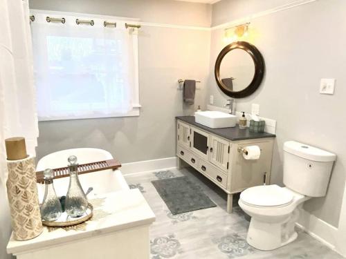 a bathroom with a toilet and a sink and a mirror at Historical Entertainer 3 Bedroom Townhouse AC PNW in Albany