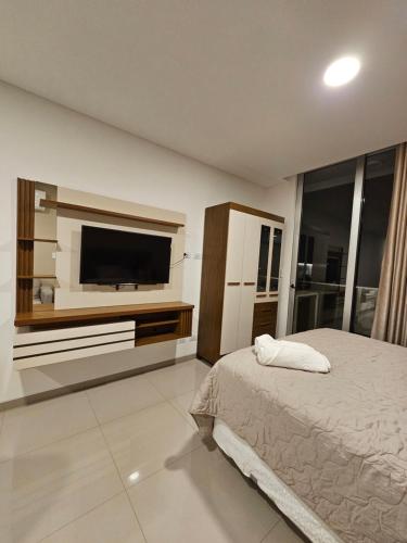 a bedroom with a bed and a flat screen tv at Departamento de lujo en EQUIPETROL in Santa Cruz de la Sierra