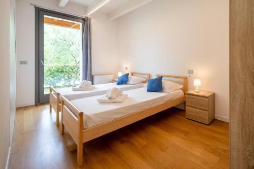 a bedroom with two beds and a large window at GardalandLuxuryApartment Pool & Free Parking in Ronchi