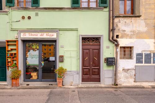 a green building with a door and a store at Romantic Suite Near Pisa Lucca in Bientina