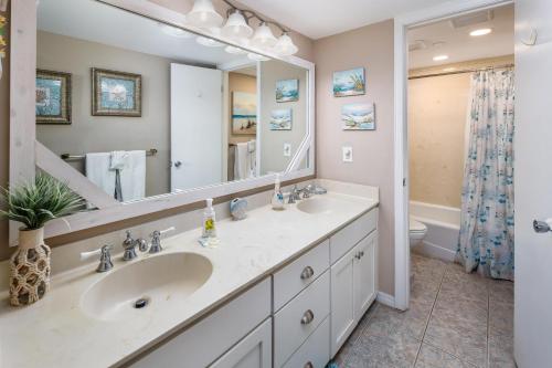 a bathroom with two sinks and a large mirror at Nautilus Unit 2310 in Fort Walton Beach