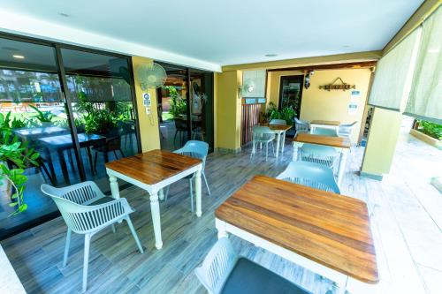 a restaurant with tables and chairs and windows at Casa Verano Beach Hotel - Adults Only in Santa Marta