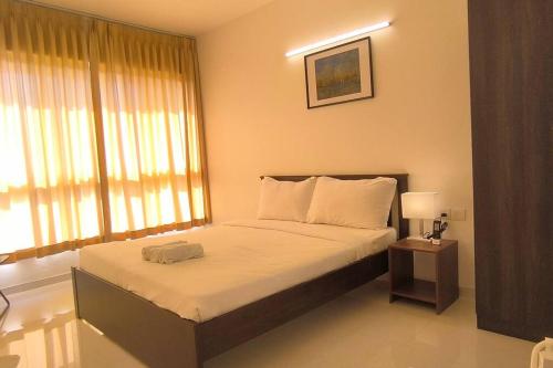 a bedroom with a bed and a large window at Goodstay Sunlit Bliss Cozy2BHK with Luxe Touch704 in Dabolim