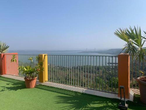 a balcony with plants and a view of the ocean at Goodstay Sunlit Bliss Cozy2BHK with Luxe Touch704 in Dabolim