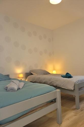 deux lits jumeaux dans une chambre avec deux lampes dans l'établissement Palmez Breizh, à Plouha