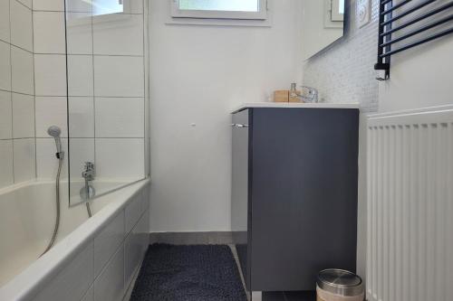 a bathroom with a bath tub and a sink at Palmez Breizh in Plouha