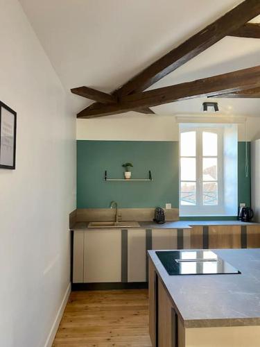 a large kitchen with a sink and a window at Sous les toits de Bourges in Bourges