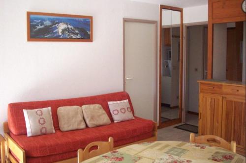 un salon avec un canapé rouge et une table dans l'établissement #AH3 The Snow White, à Huez