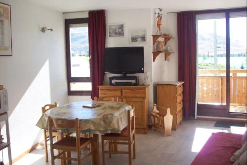 un salon avec une table et une télévision dans l'établissement #AH3 The Snow White, à Huez