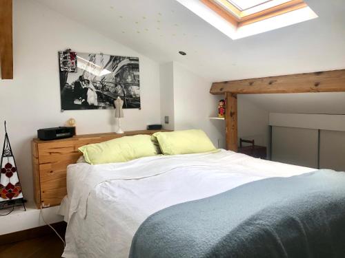 - une chambre avec un grand lit et une lucarne dans l'établissement Duplex atypique proche Montparnasse & parc expositions, à Paris