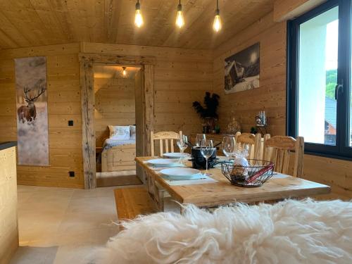 a wooden room with a table and a bed at l'écureuil, chez le charpentier d'antan, la chaleur du bois, le calme de la campagne in Epagny Metz-Tessy