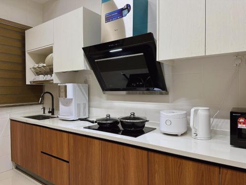 a kitchen with a stove and a microwave at 12pax-4Br3.5Ba2Lvr/BM/Juru/100in Proj/AutoCity/Ikea in Simpang Ampat