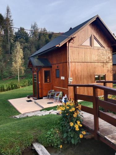 a wooden cabin with a porch and a fence at Domek Ziarno in Krościenko