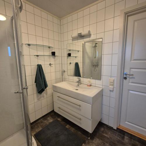 a white bathroom with a sink and a mirror at Leilighet Ytrebyen Vadsø in Vadsø