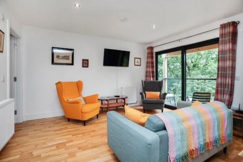 a living room with a blue couch and two chairs at 26 Strathtay Lodges in Aberfeldy
