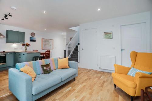a living room with a blue couch and two orange chairs at 26 Strathtay Lodges in Aberfeldy