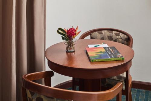 a table with a book and a vase of flowers on it at El Dorado Classic Hotel in Iquitos