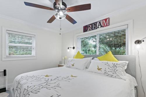 a bedroom with a white bed with a ceiling fan at Battery Place in Savannah