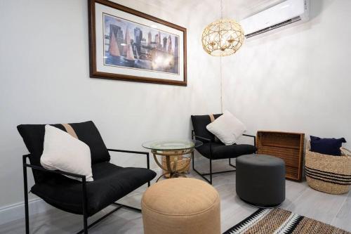 a living room with three chairs and a table at Battery Place in Savannah