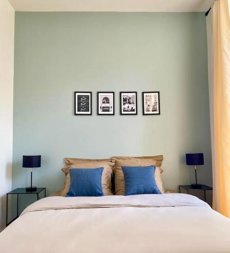 a bedroom with a bed with three pictures on the wall at Au pied de la Cathédrale de Bourges in Bourges