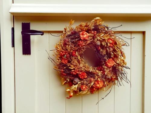 a thanksgiving wreath on a white door at Ty Bach Glas in Llanhowell